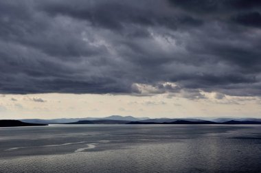 deniz üzerinde karanlık düşük fırtınalı bulutlar, denizde dalgalar