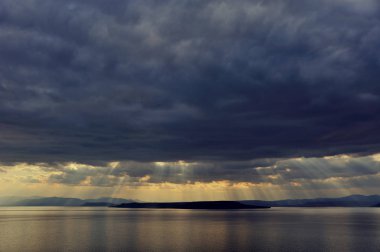 deniz üzerinde karanlık düşük fırtınalı bulutlar, fırtına öncesi manzara, gökyüzünde Raylights 