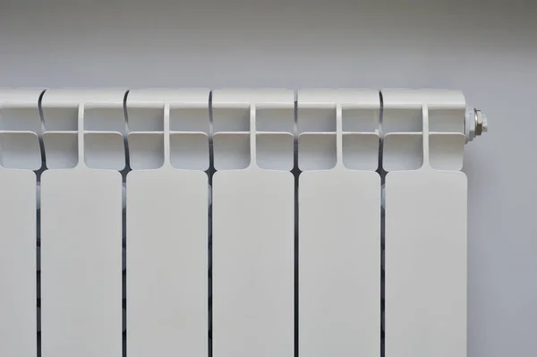 Radiateur métallique blanc sur le mur gris Image En Vente
