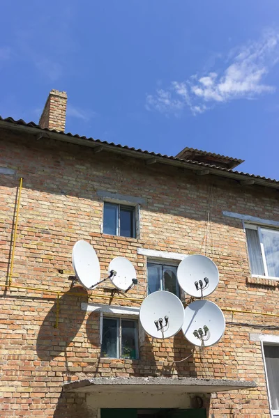 Uydu çanak tabak antenler ile kırmızı tuğlalı ev duvar