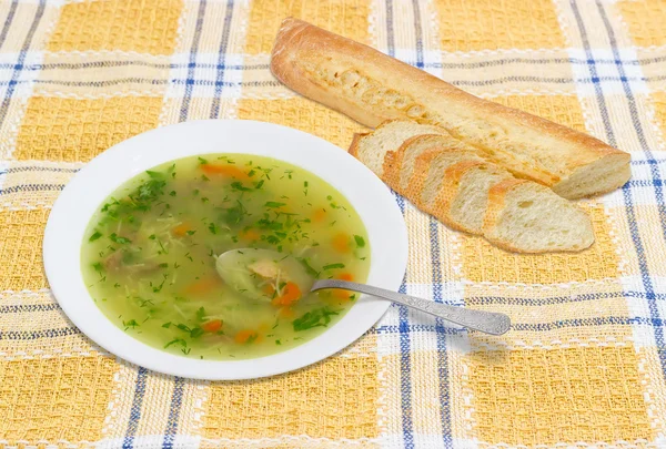 Zupa z kurczaka w białym naczyniu i bagietką na obrus w kratkę — Zdjęcie stockowe