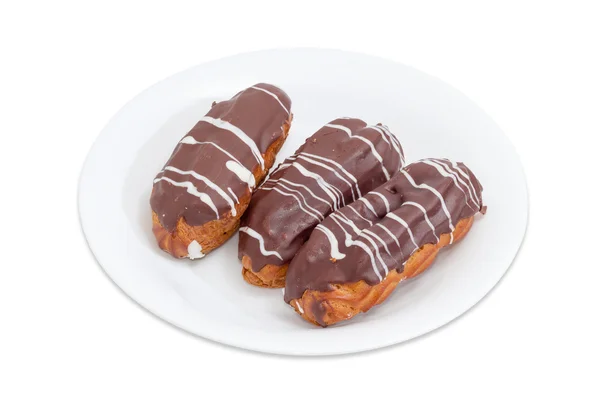 Eclairs mit Schlagsahne und Schokoladenglasur auf weißem Teller — Stockfoto