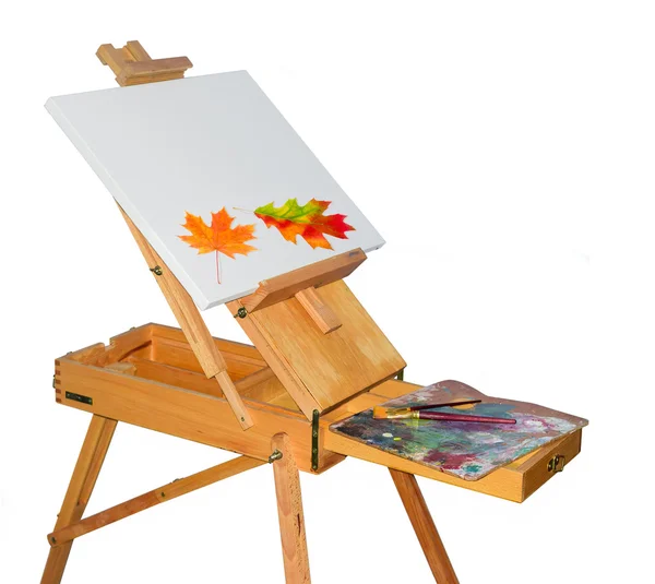 Wooden easel and autumn leaves on the empty canvas — Stock Photo, Image