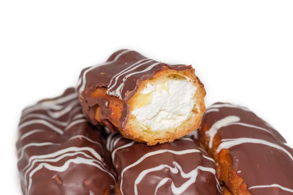 Eclairs con crema batida y glaseado de chocolate de cerca — Foto de Stock