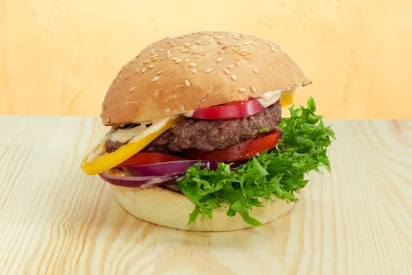 Tradiční hamburger na dřevěný povrch — Stock fotografie