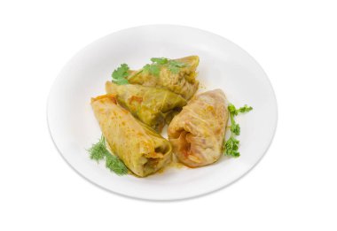 Cooked cabbage rolls and twigs of greenery on white dish clipart