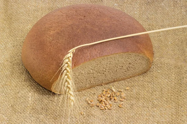Pan redondo de trigo y centeno, espiga de trigo y grano de trigo — Foto de Stock