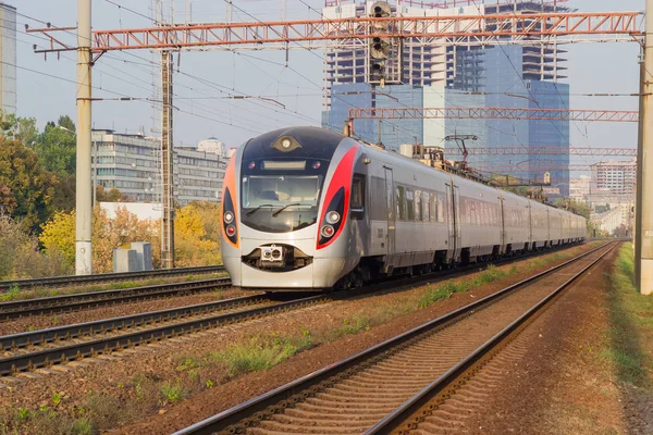 Treno interurbano per passeggeri sullo sfondo dello sviluppo urbano — Foto Stock