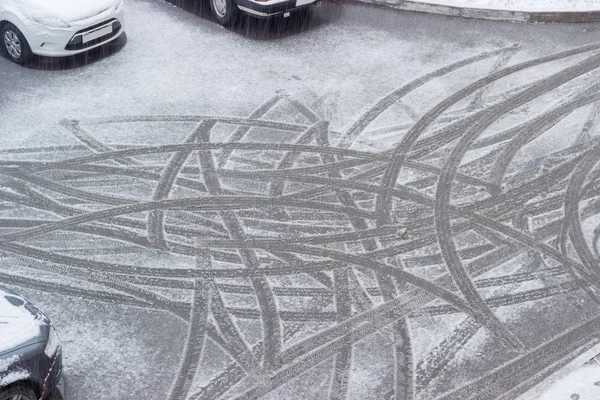 Сліди автомобільних шин на мокрій снігу під час снігу — стокове фото