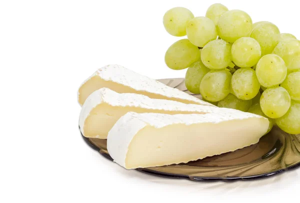 Fette di un formaggio morbido e chicchi d'uva da tavola bianchi primo piano — Foto Stock