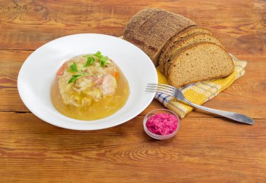 Domuz eti jöle beyaz tabak, ekmek, ahşap yüzey üzerinde çatalı