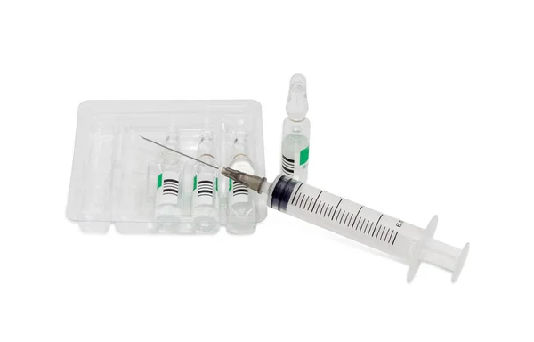 Plastic medical syringe with hypodermic needle and pharmaceutical products — Stock Photo, Image