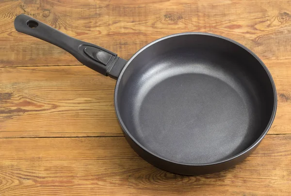 Frying pan with ceramic non-stick coating on wooden surface — Stock Photo, Image