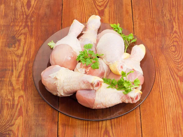 Gambe di pollo crude con verdure su piatto di vetro — Foto Stock