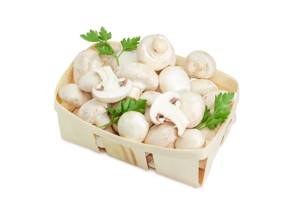 常见的蘑菇和欧芹树枝在木制的篮子里 — 图库照片