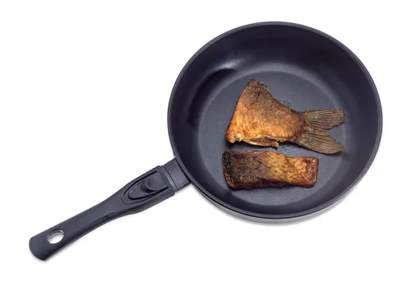 Fried slices of carp on frying pan on light background — Stock Photo, Image