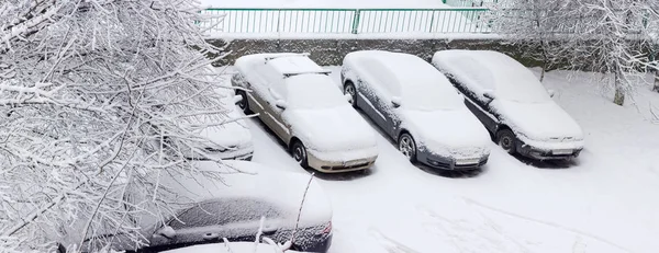 Samochody pokryte śniegiem na parkingu w okolicy mieszkalnej — Zdjęcie stockowe