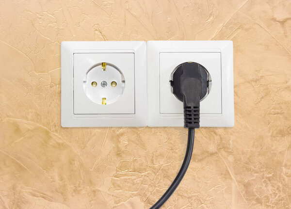 Two white socket outlets with one connected corresponding power 