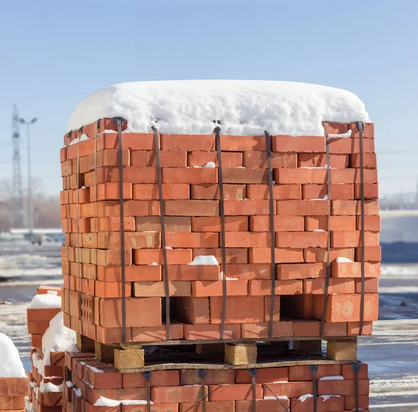 Pallets of the red bricks on a warehouse