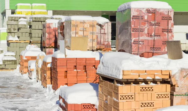 Pallets met rode bakstenen- en betonnen metselwerk eenheden voor magazijn — Stockfoto