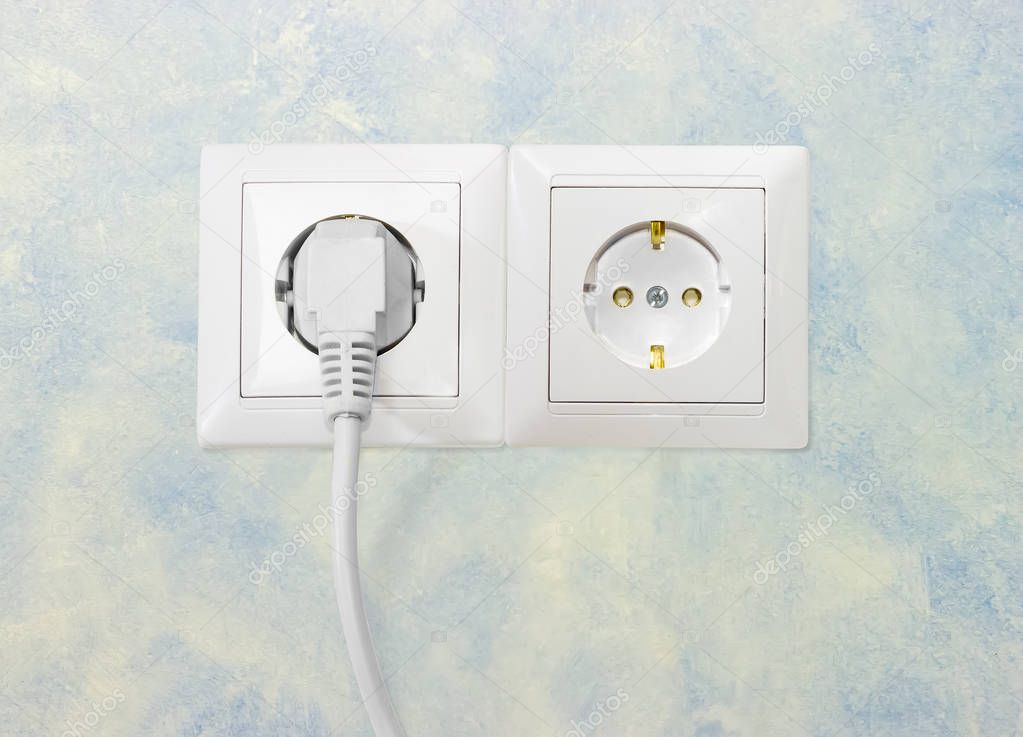 Two white socket outlet with one connected corresponding power plug
