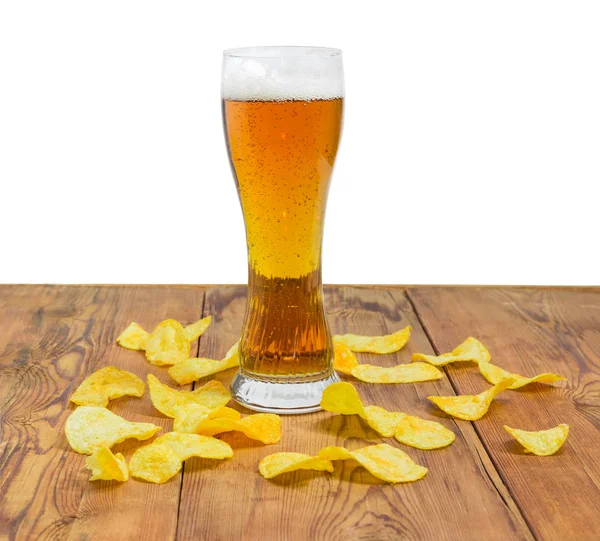 Lager beer among potato chips scattered on the wooden surface — Stock Photo, Image