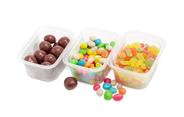 Tres variedades de caramelos diferentes en pequeños recipientes de plástico —  Fotos de Stock
