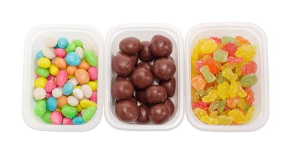 Tres variedades de caramelos en pequeños envases de plástico de primer plano —  Fotos de Stock