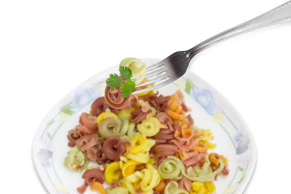 Πιρούνι με χρωματιστά μακαρόνια πάνω από το πιάτο με ίδιο ζυμαρικά — Φωτογραφία Αρχείου