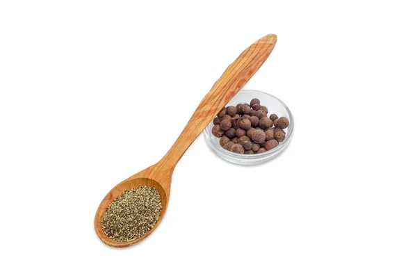 Black ground pepper in wooden spoon and allspice in bowl — Stock Photo, Image