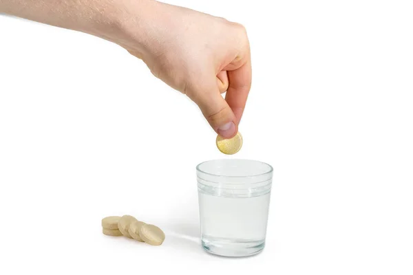 Comprimido medicinal efervescente en la mano sobre un vaso de agua —  Fotos de Stock