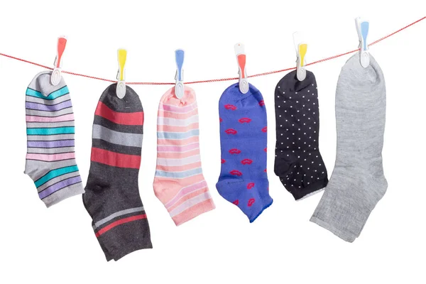 Différentes chaussettes pour hommes et femmes sur la ligne de vêtements avec une pince à linge — Photo