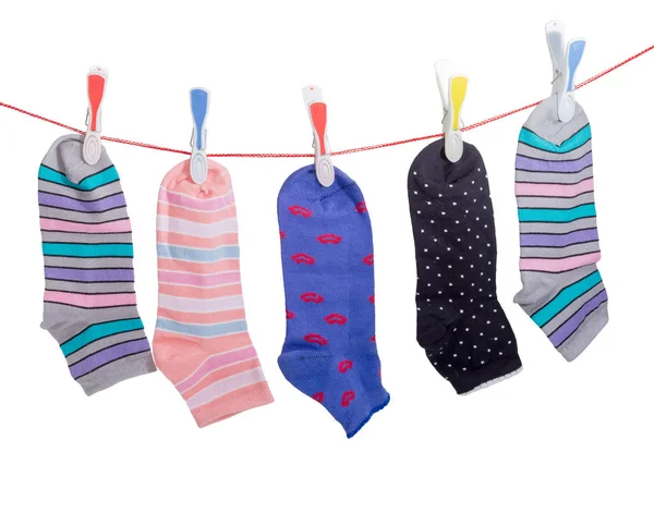 Chaussettes différentes pour femmes sur la ligne de vêtements avec des pinces à linge — Photo