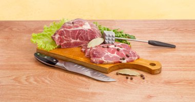 Pork neck on cutting board, meat tenderizer and kitchen knife clipart