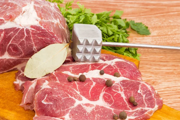 Cuello de cerdo en la tabla de cortar, especias, ablandador de carne de primer plano —  Fotos de Stock