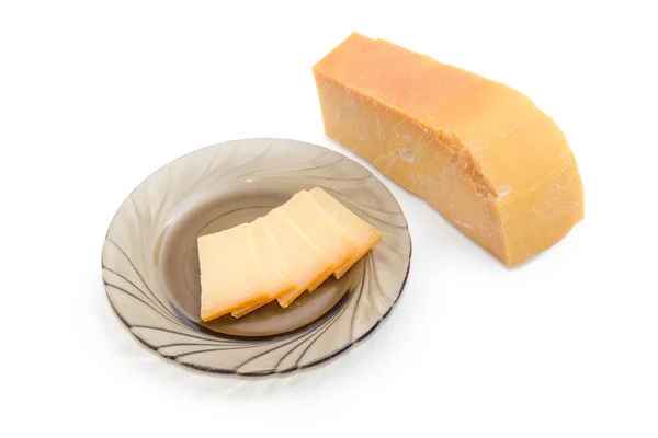 Piece and several slices on saucer of Dutch hard cheese — Stock Photo, Image