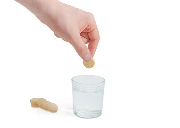 Comprimido medicinal efervescente en la mano sobre un vaso de agua —  Fotos de Stock