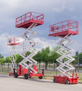 Üç farklı çalışma platformları asansörleri asfalt zeminde tekerlekli.