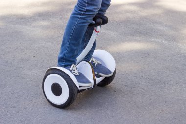 Bacaklar genç adamın kendi kendine karşı bir scooter sürme