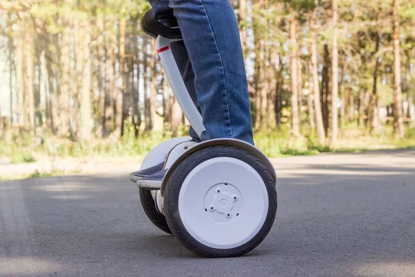 Pernas de homem jovem montando a scooter de auto-equilíbrio — Fotografia de Stock