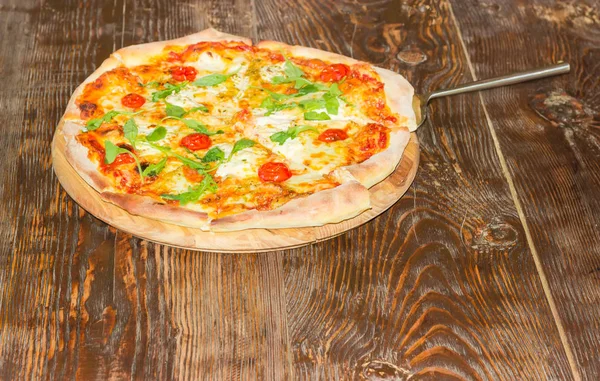 Pizza s pizza špachtle na starý dřevěný stůl — Stock fotografie