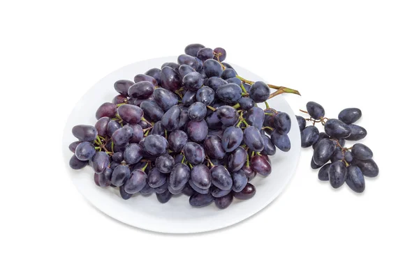 Racimos de uvas azules en un plato blanco y al lado —  Fotos de Stock