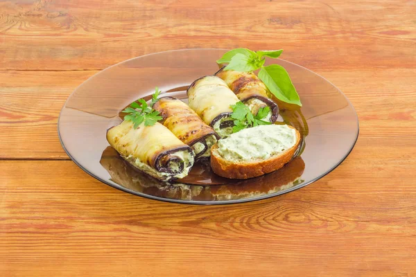 Фаршированные баклажаны и бутерброды на стеклянной тарелке — стоковое фото