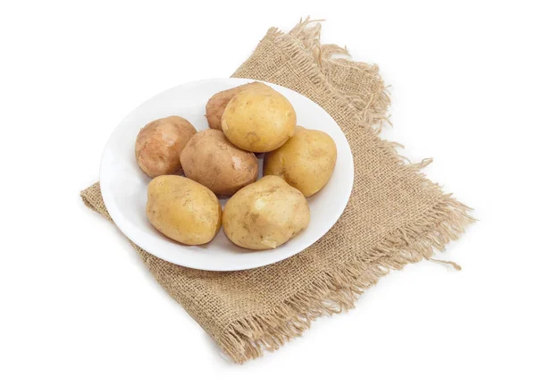 Patate bollite nelle loro pelli sul piatto su sacco — Foto Stock