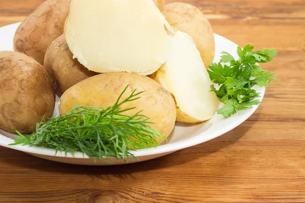 Patate bollite nelle loro pelli ed erbe su primo piano piatto — Foto Stock