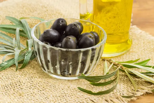 Olives noires dans un petit bol en verre gros plan — Photo