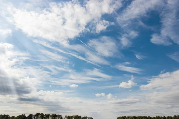 Cielo con cúmulos y cirros nubes y estelas —  Fotos de Stock