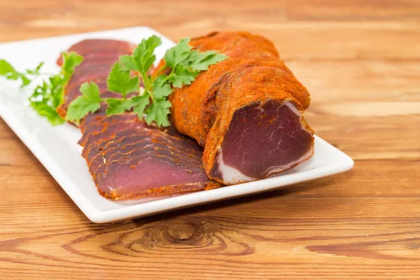 Kısmen beyaz tabak portre üzerinde kurutulmuş domuz eti bonfile dilimlenmiş