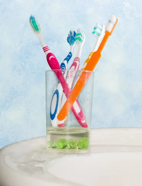 Several different toothbrushes in glass for toothbrushes — Stock Photo, Image