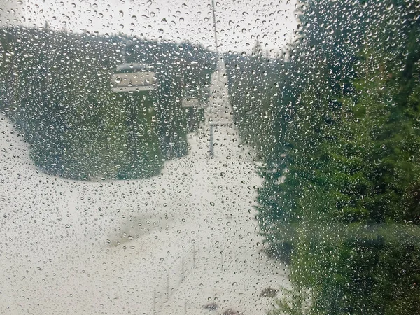 Water drops on transparent canopy of ski lift chairs